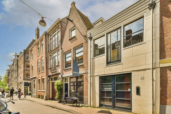 Amsterdam Hollanda Nisan 2021 Kaldırımda Yürüyen Insanların Kırmızıya Boyanmış Binaların — Stok fotoğraf