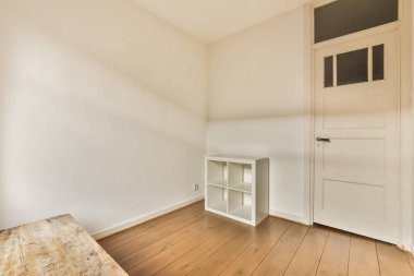 Ahşap döşeme ve duvarında beyaz boya olan boş bir oda depolama için kullanılan ahşap bir bank.