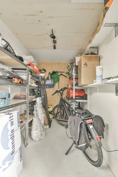 stock image the inside of a garage with bikes and boxes on the floor in front of the garage, there is a bike that has been