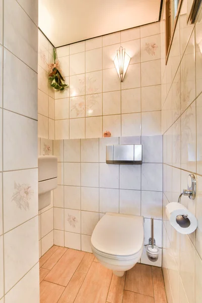 Łazienka Kafelkami Podłogą Drewnianą Ścianie Wraz Białą Toaletą Rogu — Zdjęcie stockowe