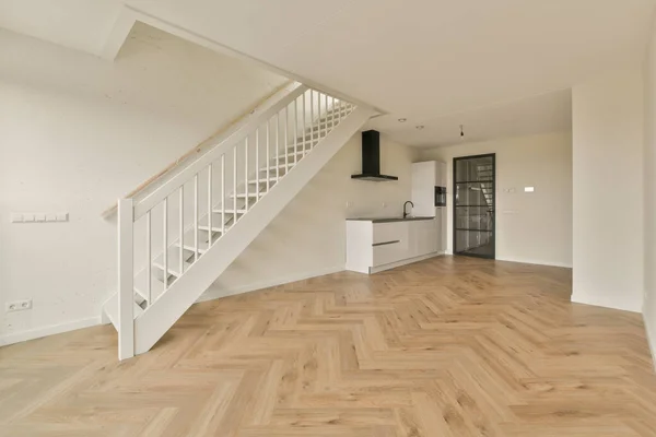 Pusty Salon Drewnianą Podłogą Białymi Schodami Prowadzącymi Drugie Piętro Domu — Zdjęcie stockowe