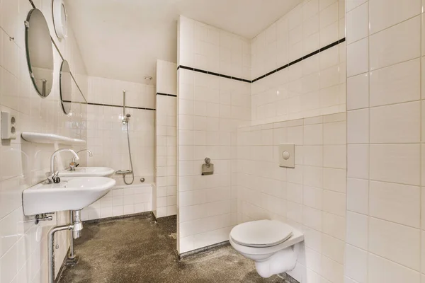 Łazienka Białymi Płytkami Czarnym Wykończeniem Ścian Wraz Umywalką Toaletą Rogu — Zdjęcie stockowe