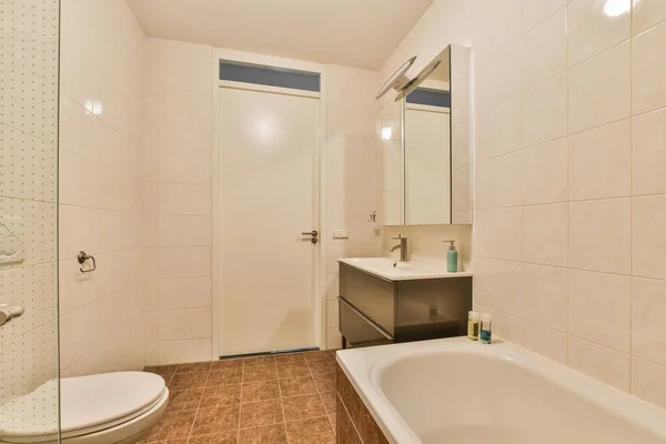 角のシャワーストールの隣の床にトイレと洗面台と浴槽のあるバスルーム — ストック写真
