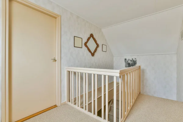 a babys cribt in the corner of a room with white walls and beige carpeted floor