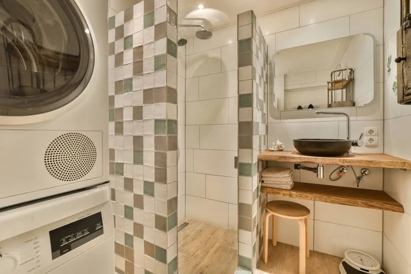 a laundry room with a washer and dryer in the corner, next to a mirror on the wall