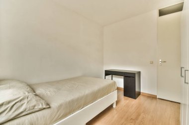 Yatak odası, masa ve ayna diğer odanın kapısının önündeki duvarda.