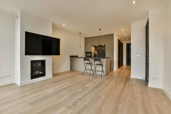 stock image a living room with wood flooring and a flat screen tv mounted on the wall in front of the fireplace