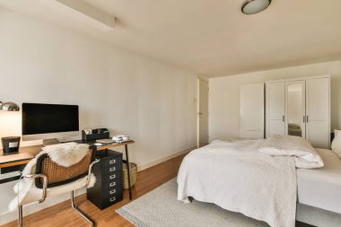 Yatağı, masası ve televizyonu olan bir yatak odası.