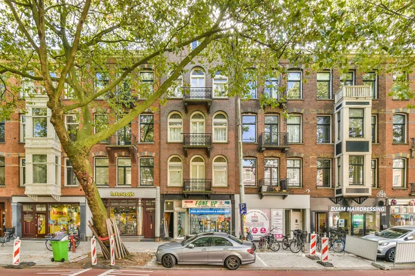 荷兰阿姆斯特丹 2021年4月10日 一条城市街道 路边停着汽车 人们在建筑物 树木和自行车前沿街行走 — 图库照片