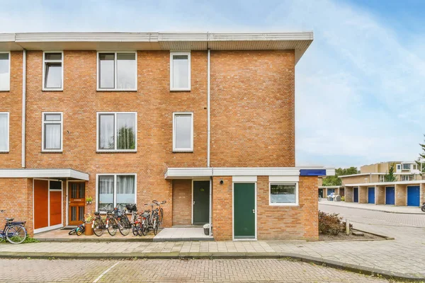 stock image Amsterdam, Netherlands - 10 April, 2021: a brick building with bicycles parked in the front and on the street next to it, there is a blue sky