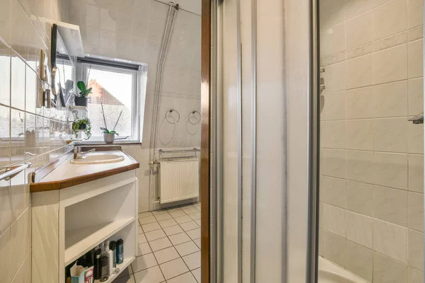 照片左边同一房间里有洗澡间 镜子和淋浴间的浴室 — 图库照片