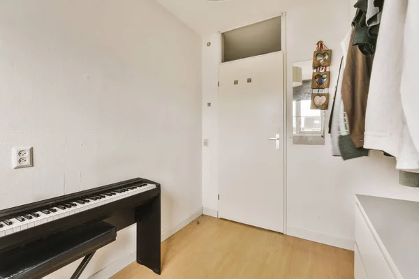 Boş Bir Oda Piyano Giysiler Duvarda Asılı Kapının Önünde — Stok fotoğraf