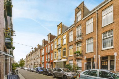 Bazı arabalar sokak kenarına park edilmişti. Tuğla binalar ve fabrikalar pencerelerden dışarı çıkıyordu.