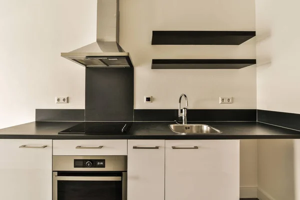 Dapur Kecil Dengan Penutup Meja Hitam Dan Lemari Putih Dinding — Stok Foto