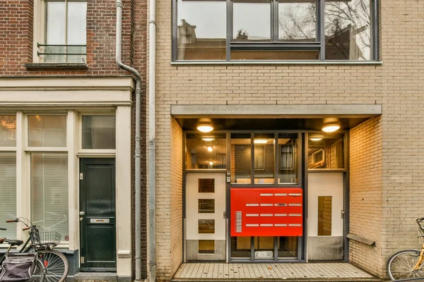 2021年4月10日 荷兰阿姆斯特丹 一辆自行车停在一座大楼前 门上挂着一个红色的盒子 两辆自行车相邻而立 — 图库照片