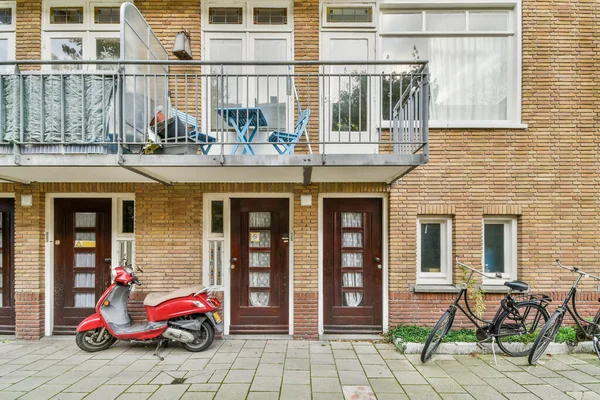 Amszterdam Hollandia 2021 Április Egy Piros Robogó Parkol Egy Téglaépület — Stock Fotó
