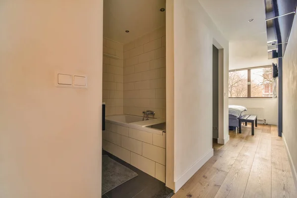 Egy Fürdőszoba Fapadlóval Fehér Csempe Falakon Valamint Egy Kád Sarokban — Stock Fotó