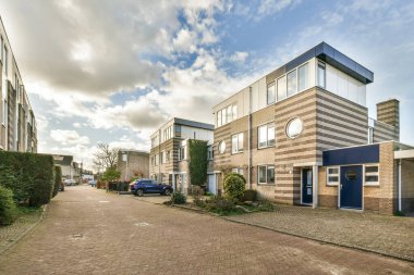 Tuğlalı bir cadde. Arabalar yan tarafta ve bulutlar gökyüzünde. Arkadan görüldüğü gibi.