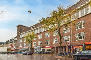 a city street with cars parked on the side and people walking down the street in the middle part of the street