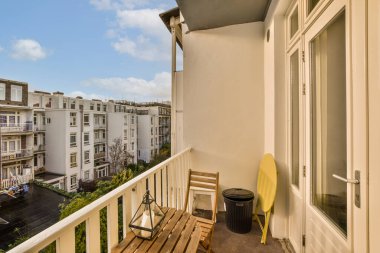 Sandalyeli bir balkon ve sol tarafında bir masa, uzaktaki sokağa bakıyor.