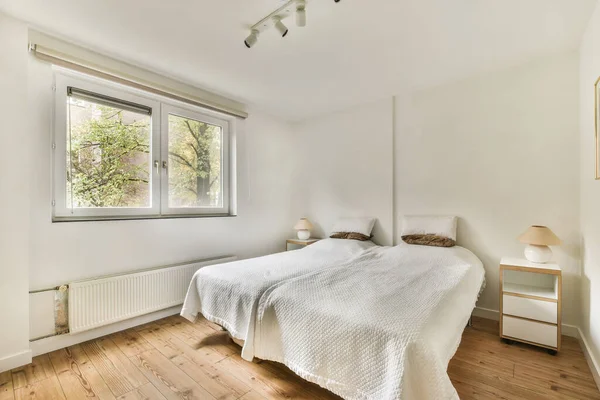 Ein Schlafzimmer Mit Holzböden Und Weißen Wänden Darunter Ein Bett — Stockfoto