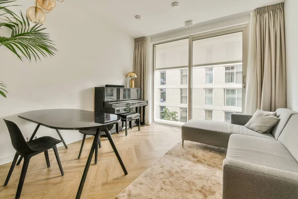 stock image a living room with a couch, table and television set in front of the sliding glass door that leads to an outside patio