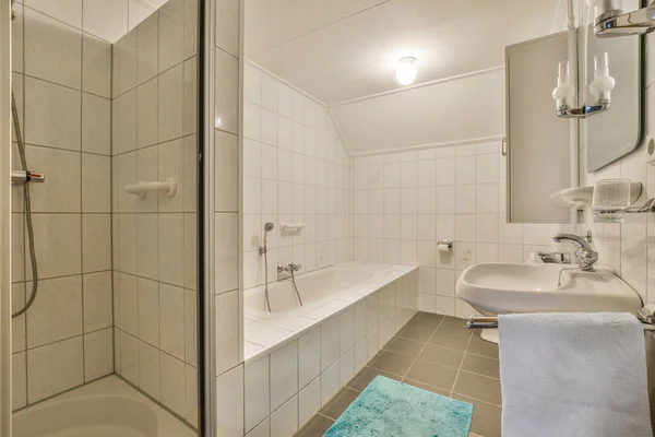 a bathroom with a shower and bath mat on the floor in front of the tub, sink, and mirror