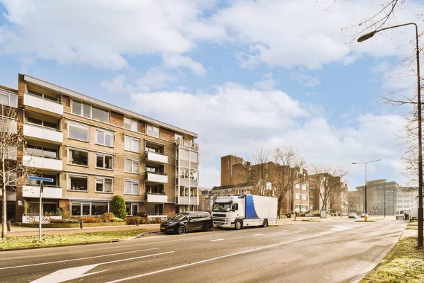 stock image a city street with cars parked on the side and buildings in the back ground, some trees to the right