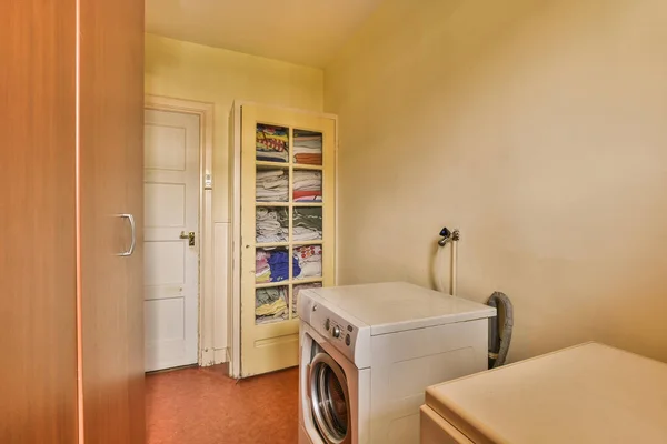 a laundry room with a washer, dryer and cabinets in the corner area on the other side of the door is open
