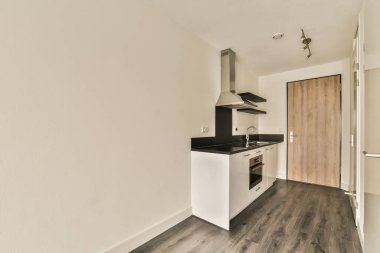 an empty kitchen with wood flooring and white walls in a room that has no furniture or appliances on it