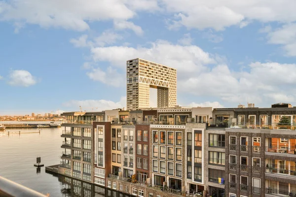 Şehrin bazı binaları, güneşli bir günde üstten geçen köprüden su ve gökyüzü ile kaplıdır.