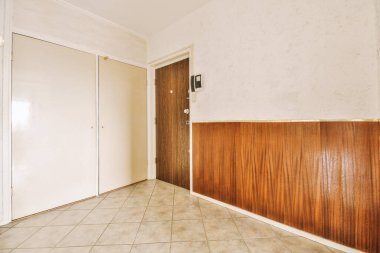 boş bir oda duvarında ahşap paneller ve iki kapı arasında döşeme, bir kapı açık.