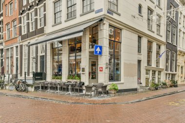 Amsterdam, Hollanda - 10 Nisan 2021: kaldırımında bisikletleri olan ve sokakta yürüyen insanların bulunduğu şehir merkezindeki bir restoran