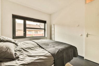 Yatağı, penceresi ve kapısı olan bir yatak odası. Dışarıdan bakıldığı gibi aynı binada.