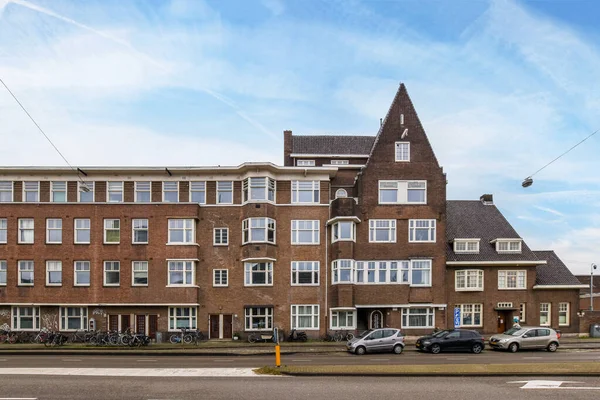 アムステルダム オランダ 2021 その前の通りの側面に駐車車と2人が通りを歩いているアパートの建物 — ストック写真