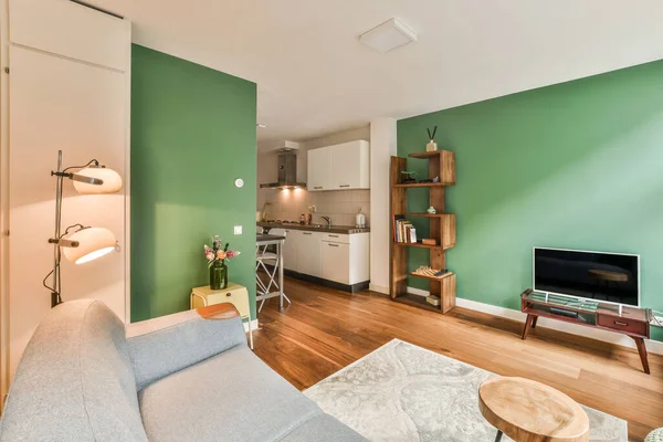 Una Sala Estar Con Paredes Verdes Suelos Madera Incluyendo Sofá — Foto de Stock