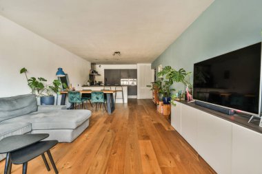 Kanepenin önündeki duvara tahta döşeme ve düz ekran televizyon monte edilmiş bir oturma odası.