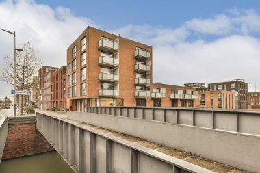 Fotoğrafın ortasında bina ve su bulunan bir kentsel alan açık ve güneşli bir günde çekilmiştir.