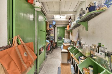 Mutfak dağınık, tezgahta bir sürü ağızlık ve arkasında da raflar var. Bu kapı başka bir odaya açılıyor.