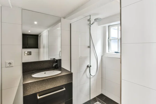 墙壁上有黑白瓷砖 镜子和淋浴间的现代化浴室 — 图库照片