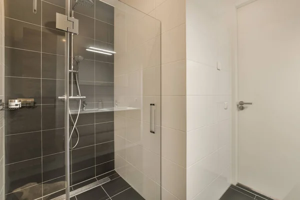 在墙角有淋浴间 墙后有瓷砖的浴室 有一扇玻璃门 — 图库照片
