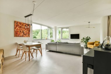 Amsterdam, Hollanda - 10 Nisan 2021: Oturma odası, yemek masası ve büyük bir pencerenin önündeki sandalyeler sokağa bakıyor.