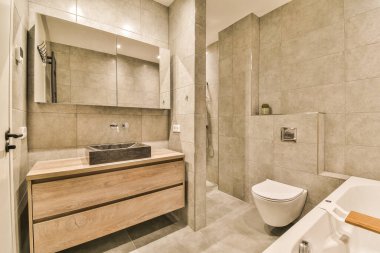 Lavabosu, tuvaleti ve küveti olan bir banyo duvarın diğer tarafında aynı odada.