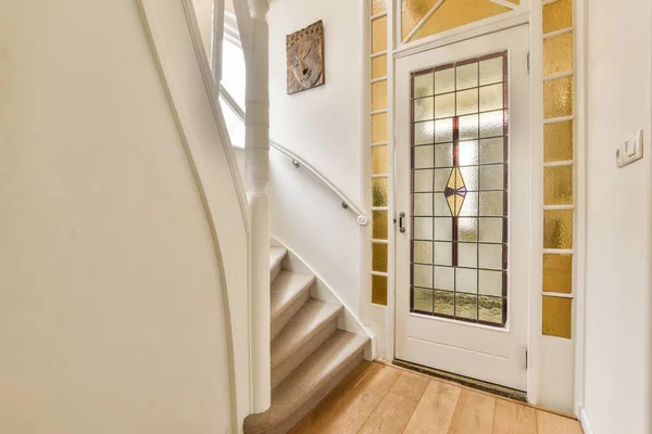 壁に木の床と白い縁がある家の中に入る道正面玄関まで続く階段 — ストック写真