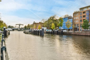 Amsterdam, Hollanda - 10 Nisan 2021: Nehir kenarındaki bazı binalar kullanılmıyor ama güzel ve temiz.