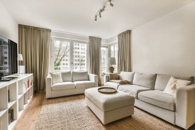 a living room with couches, chairs and a flat screen tv on the wall in front of the window clipart