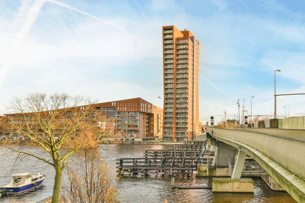 オランダ アムステルダム 2021年4月10日 青い空の下 下の川に建てられた建物やボートが係留された橋 — ストック写真