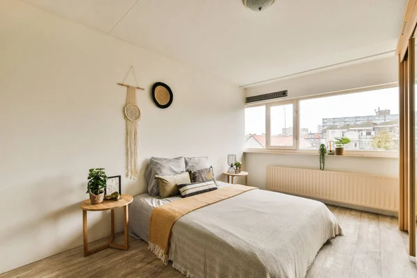 Sypialnia Białymi Ścianami Drewnianą Podłogą Pokój Posiada Duże Okno Które — Zdjęcie stockowe