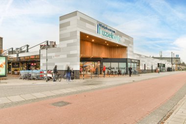 Amsterdam, Hollanda - 10 Nisan 2021: Elinde yemek zamanı yazan bir tabelayla caddede yürüyen insanlar