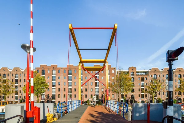 Stock image a red, yellow and blue sculpture in front of a large brick building on the other side of the street